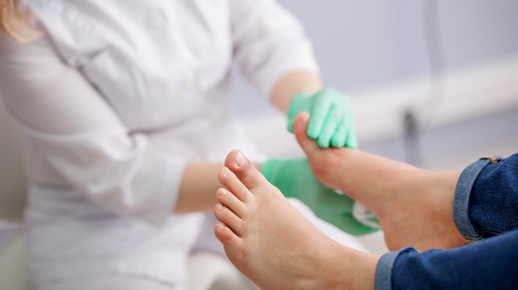 doctor, the podiatrist examines the foot